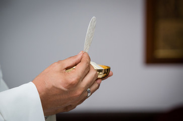 Closeup of priest with communion in the hand - Religious ceremony