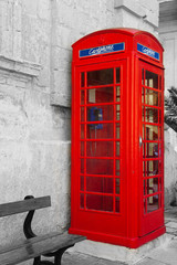 Obraz premium An iconic red telephone box in maltese town Mdina. Malta English language school education concept. Black, white and color mixed toned gift card.