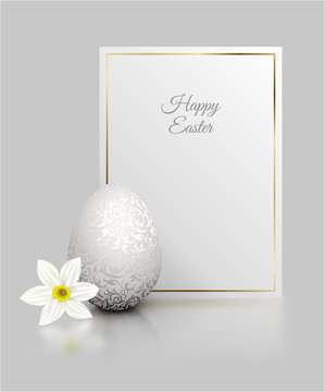 White color realistic egg with silver metallic floral pattern and Happy Easter card golden frame. White narcissus flower on light grey background with reflection. Vintage banner, card. Simple design.