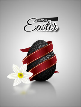 Black mat realistic egg with metallic floral pattern diagonal wrapped red ribbon. Gray background with reflection and white narcissus flower. Bright greeting card with Happy Easter text.