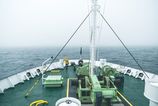 Rear view of man looking at view while standing on ship's bow