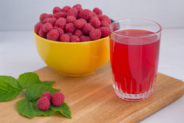 Home juicy raspberries poured in a bowl on a wooden table