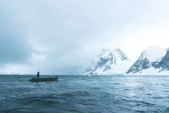 Man steering Rubber Dinghy through the Polar Landscape - Antarctica
