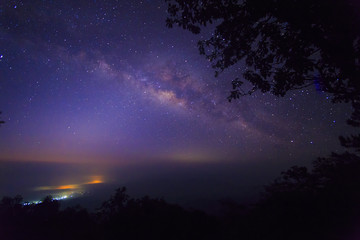 Naklejka premium The Milky Way Galaxy and silhouette of trees in the mountains. Night scene landscape at Doi Dam view point Chiang mai, Thailand.