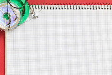 big notebook with fishing tackles on color paper background