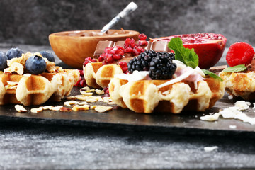 Belgian waffles with pomegranate and raspberries, homemade healthy breakfast with mint