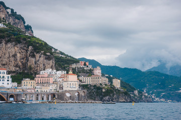 Panoramic aerial view shot of Amalfi village with the tiny beach coastline and colorful houses,...