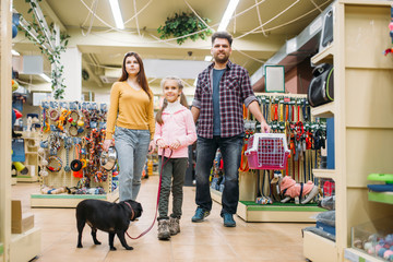 Family buying supplies for puppy in pet shop