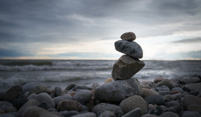 Photo of the pyramid of the stones on ocean background.
