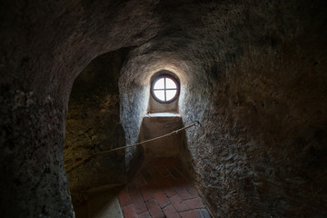 The old round window on the ancient wall of the fortress tower, Europe.