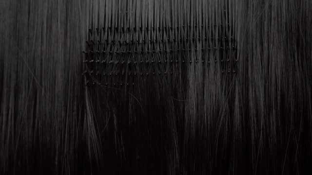 Hair texture background, no person. Black shiny hair comb texturte