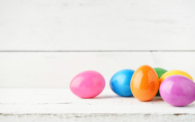 Bunte Ostereier vor weißem Holzhintergrund