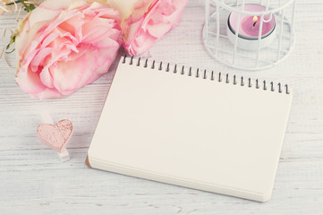 Pink roses, empty notebook