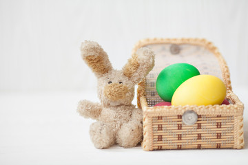Sugar rabbit and easter eggs on white wooden background.