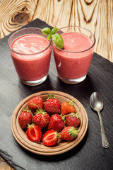 healthy strawberry yogurt with fresh berries on old wooden background