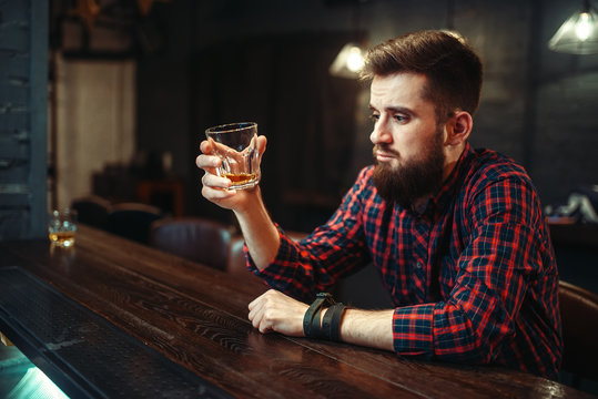 Man sitting at the bar counter and drink alcohol