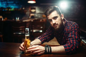 Man sitting at the bar counter, alcohol addiction