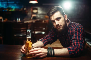 Papier Peint photo Bar Man sitting at the bar counter, alcohol addiction
