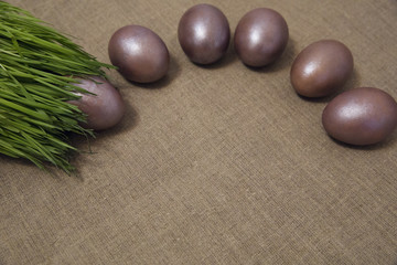 painted Easter eggs in the grass on the gray canvas