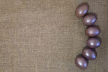 painted Easter eggs in the grass on the gray canvas