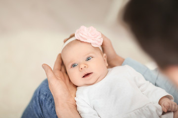 Young father with his cute little baby at home