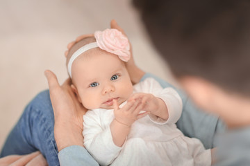 Young father with his cute little baby at home