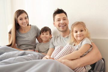 Happy family with children on bed at home