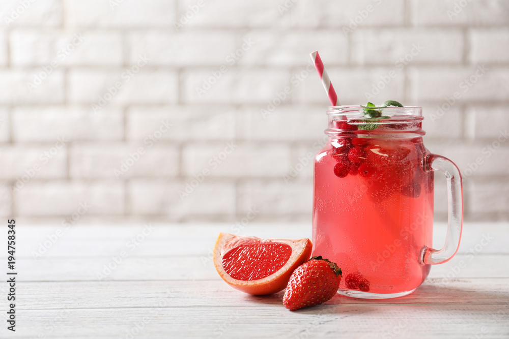 Sticker Mason jar of fresh lemonade with berries on table