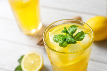 Glass of fresh lemonade on table