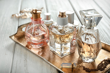 Obraz na płótnie Canvas Metal tray with perfume bottles on table