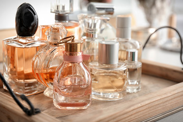 Obraz na płótnie Canvas Wooden tray with perfume bottles on table