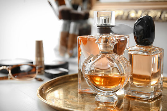 Metal tray with perfume bottles on table