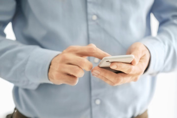 Man using phone indoors, closeup