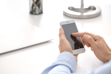 Man using phone at table, closeup