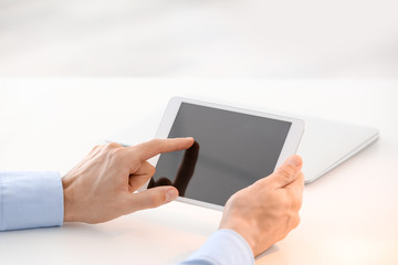Young man using tablet computer at table
