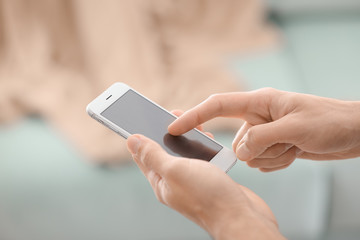Man using phone indoors, closeup