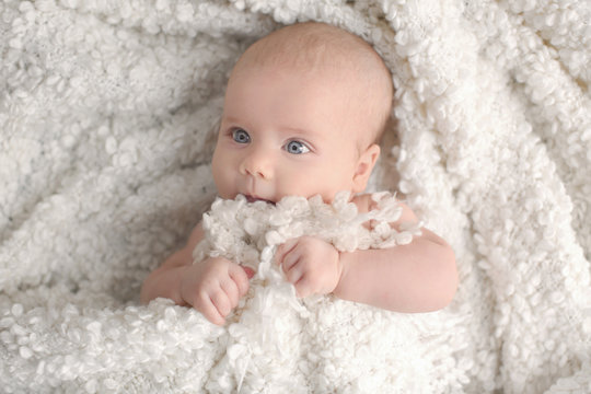 Cute little baby lying on plaid, top view