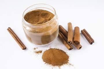 fragrant cinnamon in tubes and powder on a white background