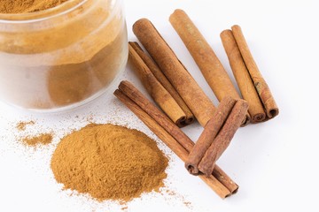 fragrant cinnamon in tubes and powder on a white background