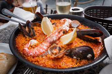 Frying pan with fresh Spanish paella is on the restaurant table. Close up.