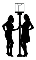 Silhouette of two girls near street light