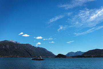 Amazing view of bright blue Como lake, Lombardy Italy, panorama of the lake and the city. Mountains on the background and good sunny summer weather