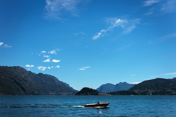 Fototapeta na wymiar Amazing view of bright blue Como lake, Lombardy Italy, panorama of the lake and the city. Mountains on the background and good sunny summer weather