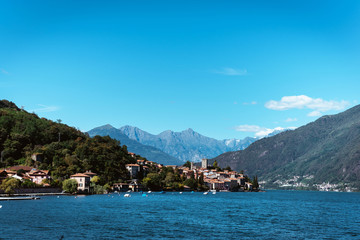 Amazing view of bright blue Como lake, Lombardy Italy, panorama of the lake and the city. Mountains on the background and good sunny summer weather