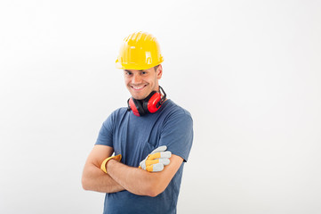 Workman with yellow hard and full protective gear smiling at the camera. Isolated over white background