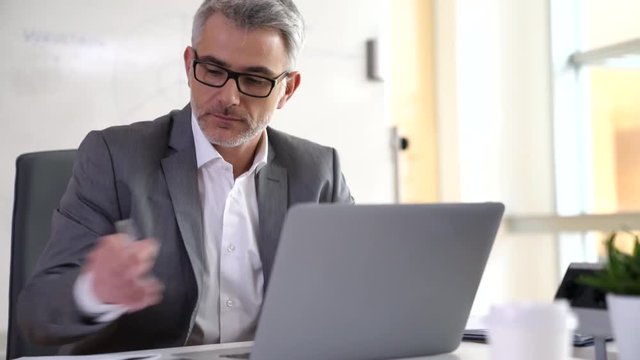 Businessman in office working on laptop 