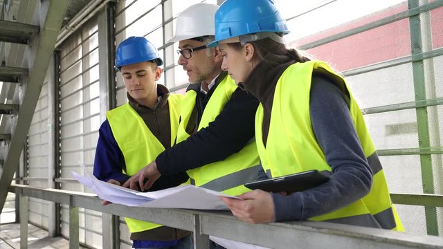 Construction site manager with young people in professional training period