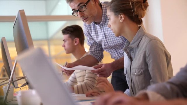 Students attending web design class with teacher
