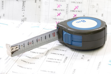 Construction blueprints with tools and measuring tape, roulette, closeup. With place for rext