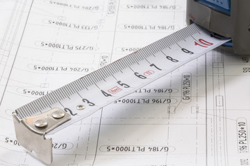Construction blueprints with tools and measuring tape, roulette, closeup. With place for rext